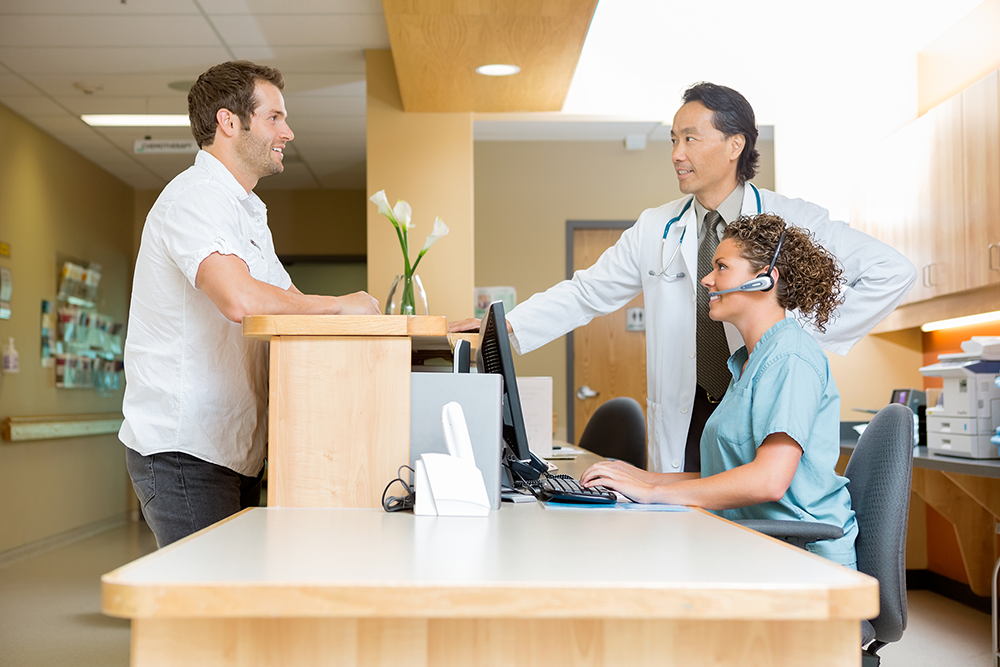 medical receptionist and doctor with patient